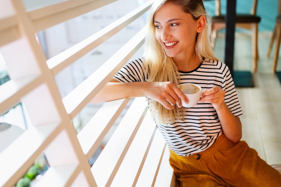 Happy sportieve vrouw met kopje koffie